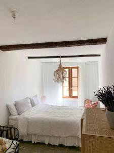 a white bedroom with a large bed and a window at Le Karlstrom - Charmante maison au coeur du Viel Antibes in Antibes
