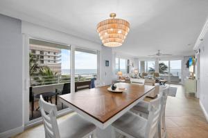 a dining room with a table and views of the ocean at Somerset three-bedroom end unit beachfront condo in Marco Island