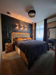 una camera da letto con un letto grande con una grande testiera di Basilica Panorama Luxury a Budapest