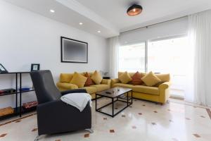 ein Wohnzimmer mit einem gelben Sofa und einem Sessel in der Unterkunft MTR - Marbella Temporary Rent Two Bedrooms Apartment Av del Mar in Marbella