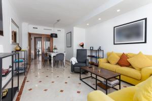 ein Wohnzimmer mit einem gelben Sofa und einem Tisch in der Unterkunft MTR - Marbella Temporary Rent Two Bedrooms Apartment Av del Mar in Marbella