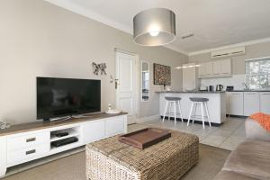 a living room with a flat screen tv and a couch at Winelands Golf Lodges 4 in Stellenbosch