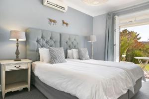 a bedroom with two beds with white sheets and horse heads on the wall at Winelands Golf Lodges 4 in Stellenbosch