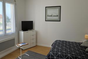 a bedroom with a bed and a television on a dresser at Studio cosy à Molsheim Calme, centre-ville et accès Strasbourg in Molsheim