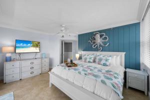 a bedroom with a bed with a blue wall at Somerset three-bedroom end unit beachfront condo in Marco Island +52 photos