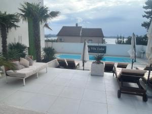 a patio with umbrellas and a swimming pool at SEA VIEW LUXURY PENTHOUSE WITH SAUNA, JACUZZI AND POOL in VILLA ZADAR SUPERIOR in Zadar