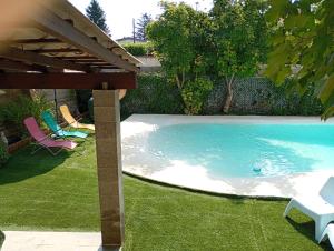 a swimming pool in a yard with chairs and a table at Maison élégance in Alès