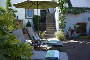 een patio met een tafel en een parasol bij Ferienhaus 1534 in Neustadt an der Weinstraße