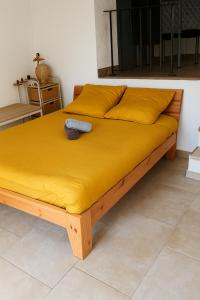 a bed with a yellow bedspread on top of it at Le Refuge de la Tour entre mer et ciel in Porri