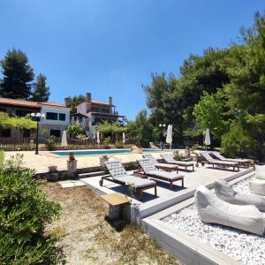 a swimming pool with chaise lounge chairs and a swimming pool at Eternal Sunset Villa #2 in Pefkohori