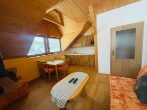 a living room with a table and a kitchen at Ubytování Heřmanka in Špičák