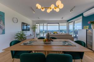 a dining room and living room with a table and chairs at Casagrande in Krk
