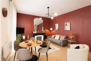 a living room with red walls and a table and chairs at Tèrra d'Automne by Rahault ConciergerieDameCarcas in Carcassonne