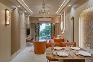 a dining room with a table and orange chairs at Orbit Serviced Apartments in Mumbai
