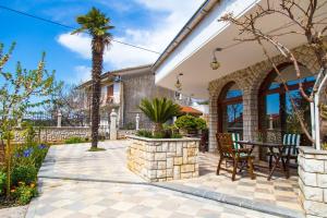 a patio with a table and chairs and a palm tree at Villa Purić in Rovinj