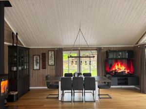 a dining room with a fireplace and a table and chairs at Nystul Panorama in Lona