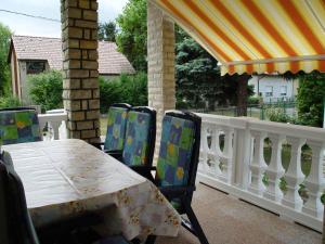 a table and chairs on a porch with a white fence at Holiday home in Balatonszarszo 48120 in Balatonszárszó