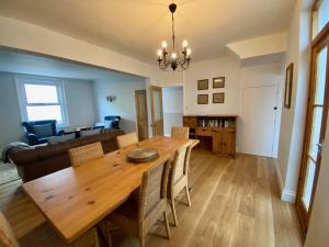 a dining room and living room with a wooden table at Killick Cottage in Sidmouth +11 photos