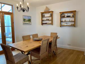 a dining room with a wooden table and chairs at Killick Cottage in Sidmouth