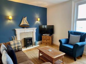 a living room with a couch and a tv at Killick Cottage in Sidmouth