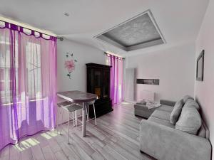 a living room with pink curtains and a couch at 1Dest - Hibiscus Home Arco in Arco +10 photos