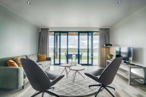 a living room with a couch and a tv at Wellness aan de Vecht - Begane grond by Droomvilla in Dalfsen