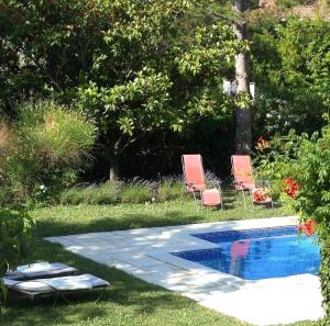 a backyard with a pool and two lawn chairs at La Maison Verte in Tulette +10 photos