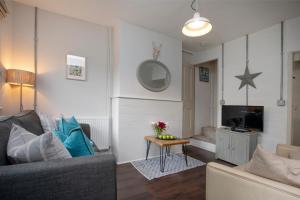 un salon avec un canapé et une télévision dans l'établissement Thyme Cottage, à East Budleigh