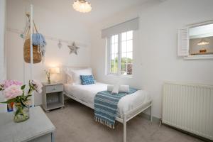 une chambre avec un lit, un bureau et une fenêtre dans l'établissement Thyme Cottage, à East Budleigh