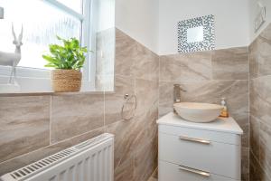 een badkamer met een wastafel en een raam bij Balamory in Exmouth +36 foto's