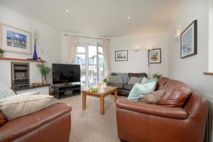een woonkamer met twee banken en een tv bij Balamory in Exmouth