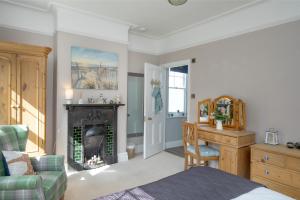 a living room with a fireplace and a bed and a desk at Budleigh Breeze in Budleigh Salterton