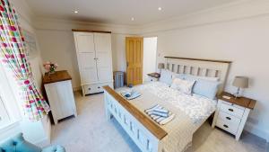 Un dormitorio con una cama grande con cabecero de madera. en Sea Mist, en Sidmouth