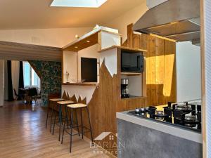 a kitchen with a counter and stools in a room at 7min de la plage - Maison typique - Cour privative in Fouras