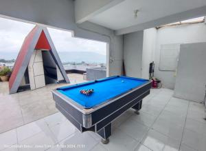 a pool table in a room with a large window at Oemah Sawah99 in Batu