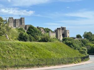 a castle on a hill next to a road at Boutique 2 bedroom apartment in Mersham