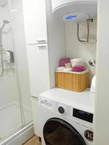 a washing machine in a bathroom with a shower at Apartman Matea - Self Check-in in Osijek