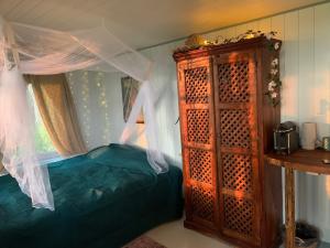 a bedroom with a bed and a wooden cabinet at Vista Vibes Glamping in Grillby