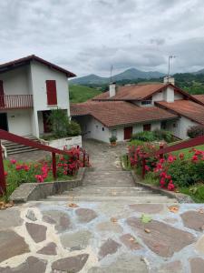 a stone walkway leading to a house with pink flowers at BAYONNE Piscine Vue Montagnes in Souraïde +7 photos