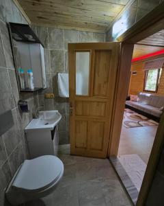 a bathroom with a toilet and a sink and a door at Mavera Suite in Uzungöl +37 photos