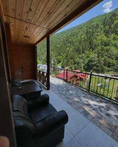a living room with a couch and a balcony with a view at Mavera Suite in Uzungöl