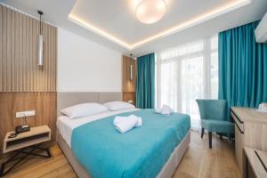 a bedroom with a blue bed with a desk and a chair at Hotel Slovenska Plaza in Budva +51 photos