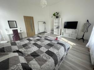 a bedroom with a black and white quilt on a bed at Apartmány LISTOPAD 17 in Děčín +18 photos