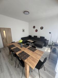 a living room with a wooden table and chairs at Apartmány LISTOPAD 17 in Děčín