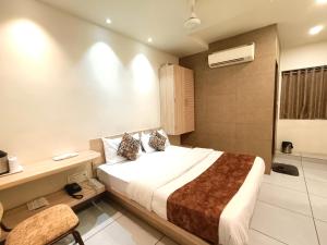 a hotel room with a bed and a bathroom at Hotel Kinara in Ahmedabad