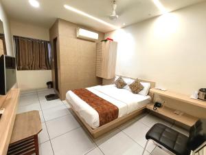a hotel room with a bed and a desk and chair at Hotel Kinara in Ahmedabad