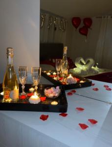 a table with two glasses and candles and wine bottles at La Casa di Fatmir in Shkodër +32 photos