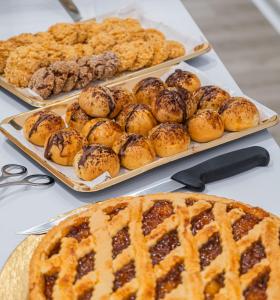 a table with three trays of pastries and a pie at Hotel Ristorante Borgo La Tana in Maratea