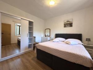 een slaapkamer met een groot bed en een spiegel bij Apartments Venilia in Lukoran