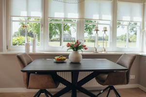 una mesa de comedor con sillas y un jarrón de fruta en NIEUW vanaf juli 2025 Vakantiewoning Borkeldrust, en Rijssen